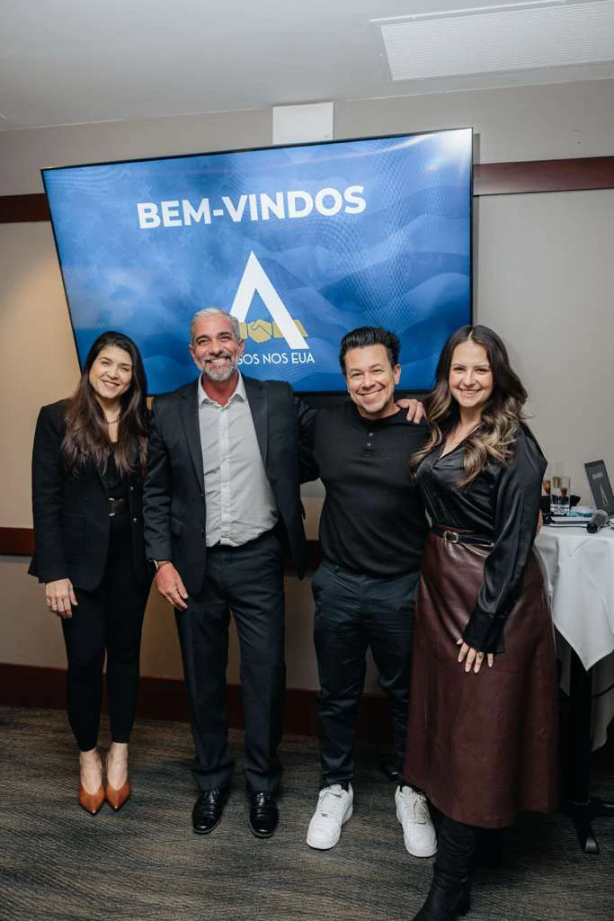 Participantes do evento Amigos nos EUA em Chicago reunidos em frente ao painel de boas-vindas, celebrando a chegada oficial do projeto à cidade